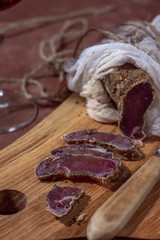 Sliced ​​sliced ​​meat cuts on a wooden board vertical layout dark style