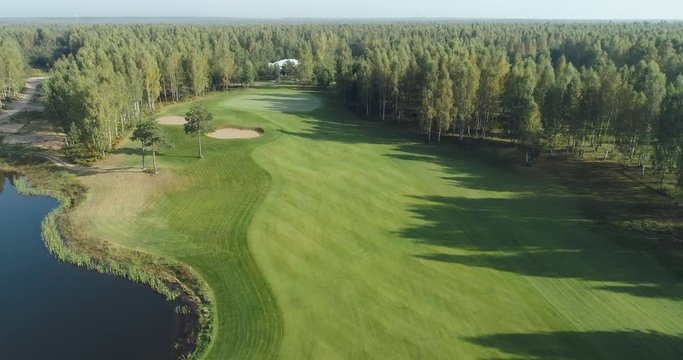 Summer sunny day, aerial view of golf course in forest area, Golf Club, view of the field of green lawn near the forest and lakes.