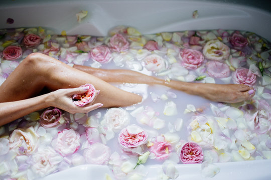Beautiful girl in the bathroom with many flowers.