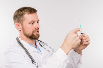 Bearded young successful doctor with syringe going to make injection