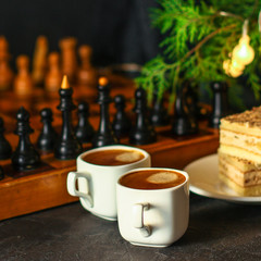coffee, piece of cake (festive atmosphere, chess, Christmas lights, new year) menu concept. food background. top view. copy space