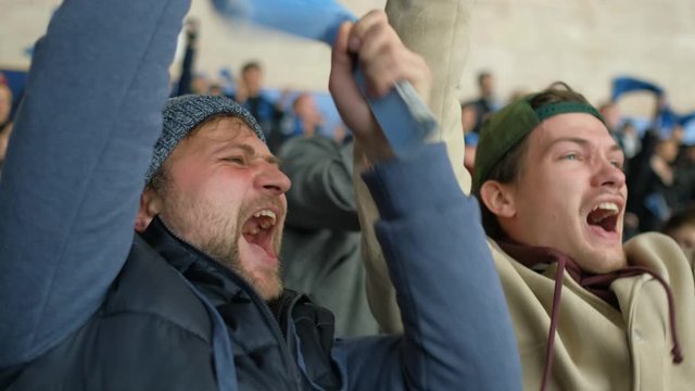 Male hockey fan watch loudly support guys on ice. Portrait hockey fan expression screaming sport game in crowd closeup cheering team emotion 4K. Person scream cheering of sport play in match arena.