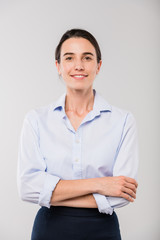 Happy young elegant businesswoman in white shirt standing in front of camera
