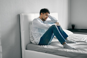 man sitting on sofa and using laptop