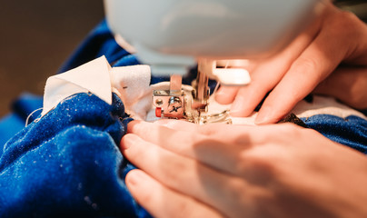 Young tailor sewing christmas decorations for children's party. Selective focus. Shallow depth of...