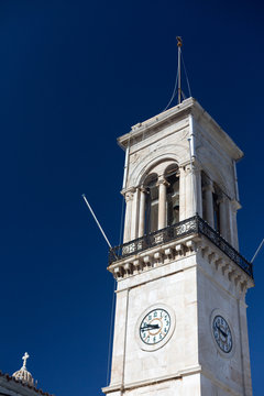 Bell tower with clock in Hydra Island, Greece on sunne day with clear classic blue sky . Vertical