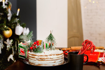 Christmas cake on the table near the Christmas tree