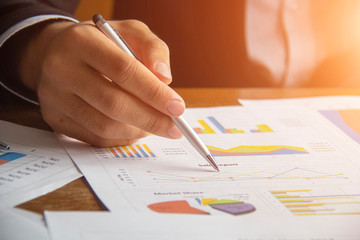 Close-up hand of businessman working on graph documents