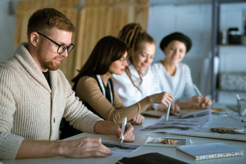 Young creative designer drawing sketch for new fashion collection