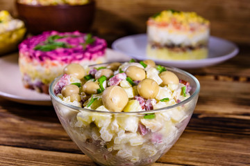 Set of festive mayonnaise salads on wooden table