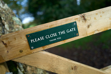 Please close the gate sign on a public footpath in the English countryside.