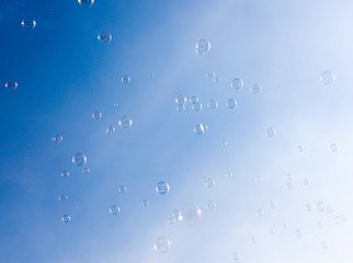 Soap bubbles fly in the blue sky