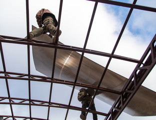 A worker mounts a metal canopy