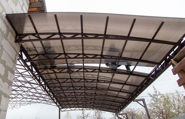 A worker mounts a metal canopy