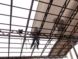 A worker mounts a metal canopy