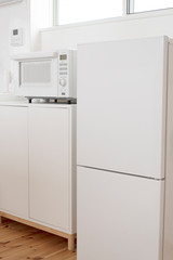 白物家電（白いミニ冷蔵庫と電子レンジ）のあるミニキッチン　白　キッチン　シンプル　白背景　背景　素材　新生活　一人暮らし　家電　文字スペース　コピースペース　余白　グラフィック素材