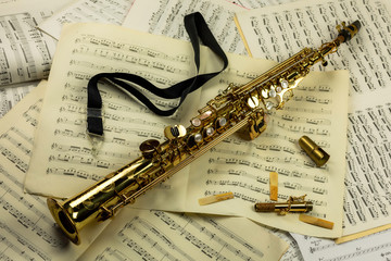 Soprano saxophone lying on a background of music