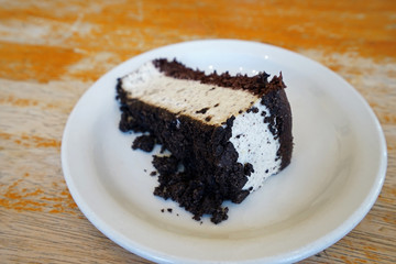 Close up slice of cookie and cream cheesecake on wooden table