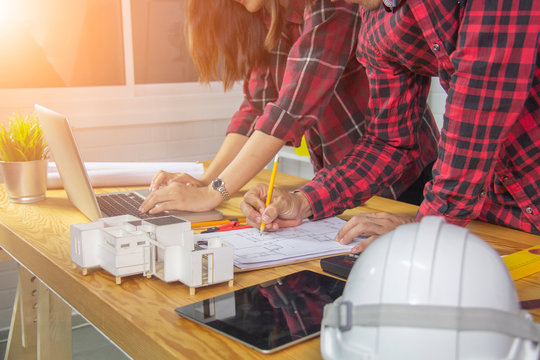 Two professional architects working at the desk. He is currently convening a blueprint for the concept of engineering and architecture.