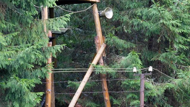 Prison or forced-labour camp watch tower in the forest in Russia or Soviet Union tilt up.