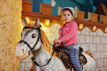 Fototapeta na wymiar little girl on the carousel horse.