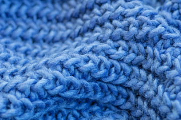 Blue knitted fabric closeup. Knitted wool background. Handmade.
