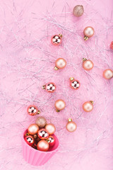 Christmas composition. Christmas baubles, gold decorations on glitter shreds and pink background. Flat lay, copy space, top view. Festive decorations 2020 celebration. New Year. Merry Christmas card. 