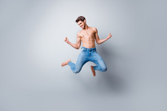 Full length photo of crazy macho man guy jumping high topless torso metrosexual hot body competitive mood celebrating successful competition wear jeans isolated grey background