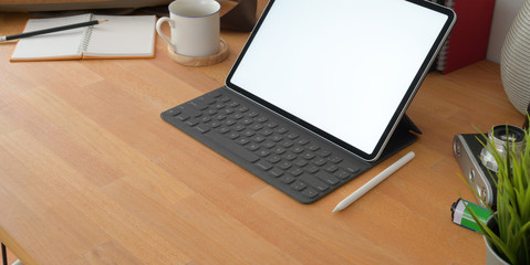 Cropped shot of comfortable workplace with blank screen digital tablet and office supplies