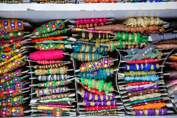 Colorful tailor supplies like ribbons and embroidery material in a street shop in the tailor market in Mumbai, India.