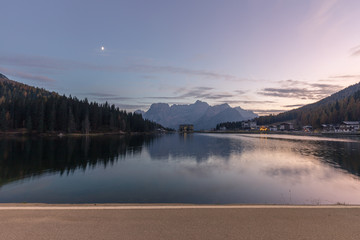 Fototapeta na wymiar Night in Lake Misurina, natural landscapes with the moon in the sky in Dolomites, Italy