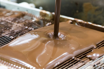 Chocolate mixer machine at the chocolate factory, Melted chocolate. enrobing chocolate