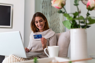 Pretty woman shopping online with credit card. woman holding credit card and using laptop. Online shopping concept of beautiful woman shopping from home