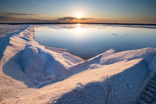 Nature reserve Saline Margherita di Savoia, Apulia, Italy: The salt pan. Salt flats area for sea salt production. A salt marsh, an ecosystem on Adriatic sea. Heaps of salt at sunset ready for harvest