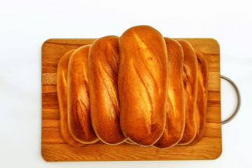The white background of the horizontal photo shows fresh pastries on a wooden Board. White bread with Golden crust