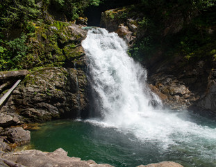 Obraz premium Thundering emerald colored punchbowl waterfall North Fork Sauk River Falls of the north cascades in a rocky gorge off Mountain Loop Highway in Darrington Snohomish county Washington State 