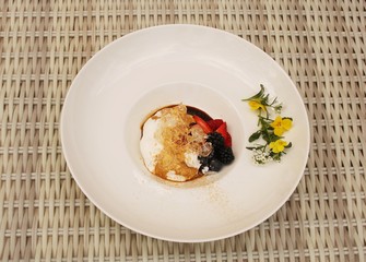 Delicious dessert of tender curd and berries on a white plate