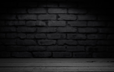 Wood table in front of rustic brick wall blur background with empty copy space on the table for product display mockup. Retro design montage presentation.