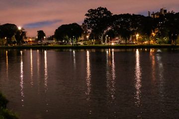 Fototapeta premium At the beginning of the night, the lights of the city reflect on the water