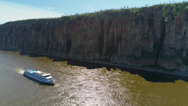 Cruise ship floating on largest river Lena unique pillars vertical cliffs best Russia Siberia Yakutia natural wonder. World heritage reserve landscape. Travel tourism. Summer sunny day. Aerial decline