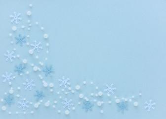 Christmas composition. Snowflakes and beads on pastel blue background. Flat lay, top view, copy space