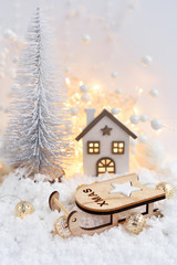 Christmas composition with the sleigh, decorative hut and festive decorations оn the snow. Christmas or New Year greeting card.