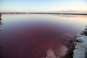 Nature reserve Saline Margherita di Savoia, Apulia, Italy: The salt pan. Salt flats area for sea salt production. Coastal ecosystem on Adriatic sea. Red waters colored by alga Dunaliella salina