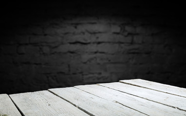 Wood table in front of rustic brick wall blur background with empty copy space on the table for...