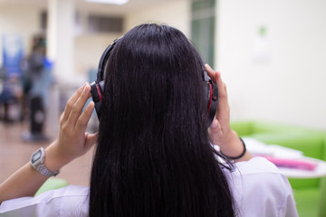 Fototapeta premium Women wear headphones to relieve stress, while working by listening to music.