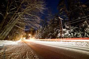 night photo of a winter road among the trees in the snow. USA. Maine Portland