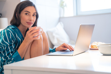 Obraz premium Hot tea and laptop at the weekend at home stock photo