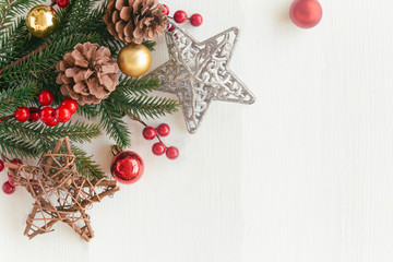 White wood with pine leaf, pine cones or conifer cone, holly balls, star, candy cane and bauble in Christmas concept. Wood plank background in top view flat lay with copy space for Christmas wallpaper