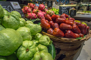 Variety of organic Asian fruit guava, Rose Apple, Pitaya in baskets at the modern hypermarket.