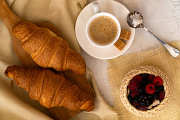 Two croissant. freshly baked croissants  and espresso on brown background 